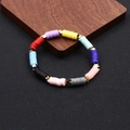 Nahaufnahme eines bunten Heishi-Perlenarmbands mit goldenen Sternanhängern und Gummiband - Mehrfarbiger Stern-Stil