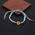 Detail of light blue hand-woven daisy bracelet with adjustable bronze slider bead - Sky Blue