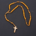 Macro view of 8mm brown wooden prayer beads with detailed crucifix pendant on woven cord - Tan