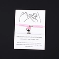 Macro shot of magnetic heart charm on pink and white woven couple bracelets - Pink White Rope Pink Steel Magnetic Heart