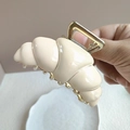 Detaillierte Nahaufnahme einer cremefarbenen Croissant-Haarklammer mit goldener Metallfeder - Weiß 8cm