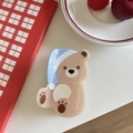 Dettaglio di una graziosa molletta per capelli a forma di orso in acetato su sfondo di libro - Orso Cappello Blu