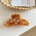 Detailed macro view of large amber tortoise hair claw clip with floral patterns and rhinestones - Caramel (10cm)