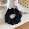 Dettaglio ravvicinato di uno scrunchie in maglia nera con bordi argentati glitterati - Nero