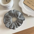Vista dettagliata dell'elastico in maglia grigia con pizzo nero su un piatto decorativo - Grigio