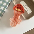 Macro detail of jellyfish hair claw clip with floral patterns and vibrant orange gradient - Star Style Orange 9.5cm