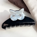 Detail of a large black acetate hair claw featuring a white shell texture cat with crystal eyes - White 9cm