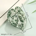 Detail showing leaf-shaped acetate hair claw with white veins and dimensions 8.5x6.2cm - White Green
