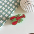 Detailed top view of a lobster-shaped acrylic hair claw clip on a minimal desk setup - Green Lobster