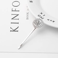 Macro di un fermaglio per capelli a girasole in argento con strass su un piatto - Argento