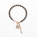 Detail of double-layer beaded bracelet with golden flower pendant and crystal accents - Black Beads with Flower Charm