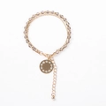 Detail eines doppellagigen Perlenarmbands mit Goldkette und rundem Kristallanhänger - Grau