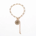 Close-up of double-layer beaded gold bracelet with a crystal-encrusted disc pendant - Grey/White