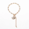 Détail d'un bracelet doré à plusieurs rangs avec pendentif coquillage et fermoir - Blanc Cassé