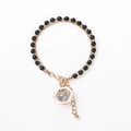 Handmade beaded bracelet with black onyx-style beads and gold ring pendant on white background - Black Beads with Round Stone Charm