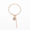 Detail of beaded layered bracelet with gold flower charm and sparkling crystal accents - Creamy White Beads with Flower Charm
