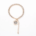 Close-up of double-layer beaded gold bracelet with grey faceted stones and round pendant - Gray Beads with Round Charm
