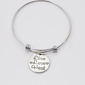 Macro shot of silver metal bangle featuring a round tag with Live Love Heal engraving - Live Love Heal Heart Style (Style A)