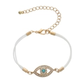 Minimalist gold Evil Eye bracelet with blue crystal and white band on white background - PU White