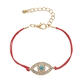 Detail of red braided cord bracelet featuring a gold evil eye charm with blue zircon stones - Red Wax Rope