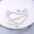 Silver snake-shaped wrap arm cuff with detailed scale texture on white ceramic tray - Silver