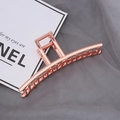 Elegante pinza para el cabello de metal oro rosa con bisagra sobre fondo de malla gris - Oro rosa