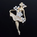 Primer plano de un broche de bailarina dorada con cristales brillantes sobre fondo negro - Estilo Bailarina de Ballet / Dorado
