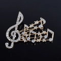 Vista dettagliata della spilla a nota musicale placcata oro con strass trasparenti - Bianco