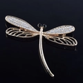 Dettaglio macro della spilla a libellula dorata con strass bianchi e ali intagliate - Libellula in Strass Bianco