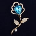 Detailed macro of rose brooch with large blue teardrop gemstone and pavé diamonds - Blue