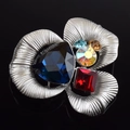 Macro shot of elegant silver flower brooch with deep blue and red faceted gemstones - Flower Shape / Dark Blue