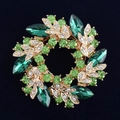 Close-up of green crystal floral brooch with gold metallic finish on black velvet - Green Scarf Buckle