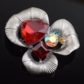 Macro view of floral brooch with colorful gemstones and brushed silver metal texture - Flower Shape / Red