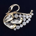 Vista macro de broche de cisne dorado con cristales champán y brillantes diamantes - Blanco