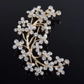 Dettaglio della spilla a ramo di cristallo con fiori di strass su lega dorata - Bianco