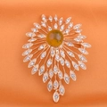 Macro shot of sunburst brooch with yellow amber stone and crystals on orange silk - Stars Shimmer (Amber)