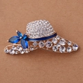 Spilla a cappello dorata con cristalli scintillanti e fiore di gemma blu - Forma di Cappello Carino