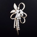 Close-up of golden crystal flower brooch with sparkling rhinestones and ribbon design - Gold