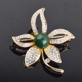 Spilla a fiore dorata con strass scintillanti e una grande pietra ovale verde - Ambra Blu a Cinque Foglie