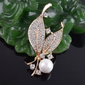 Macro-detail van goudkleurige bladvormige broche met kristallen en een grote parel - Gouden Blad Kunstparel