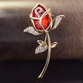 Macro shot of rose brooch with a large red faceted crystal and sparkling white rhinestones - Red