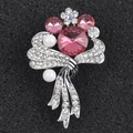 Macro shot of elegant pink crystal brooch with white pearls and silver ribbon base - Pink