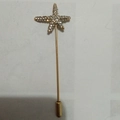 Dettaglio della spilla a stella marina dorata con strass e cappuccio di sicurezza in metallo - Oro