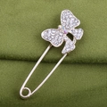 Primer plano de broche de mariposa de cristal con diamantes en tela verde oscuro - Mariposa Pequeña
