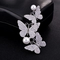 Elegante spilla a farfalla in argento con tre farfalle e perle bianche su sfondo scuro - Stile a Tre Farfalle / Oro Bianco