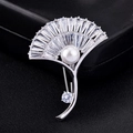 Eleganter silberner Blatt-Anstecker mit Zirkonia und Perle auf schwarzem Leder - Weißgold Blatt