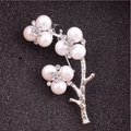 Dettaglio macro di un'elegante spilla a fiore con perle d'imitazione e strass scintillanti - Ramo d'Argento Perla Bianca / Argento