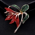 Elegante broche de flor de narciso con cristales rojos y verdes sobre base de metal dorado - Narciso