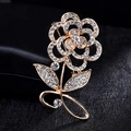 Eleganter goldener Rosen-Broschenstecker mit schimmernden Kristallen auf schwarzem Grund - Goldene Blume