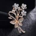 Elegante spilla a bouquet dorata con strass su una scatola di gioielli nera - Oro